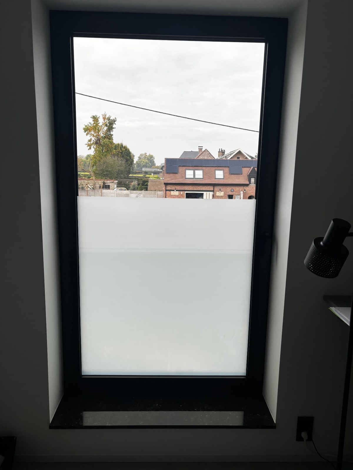 Raam met zandstraalfolie op het onderste gedeelte en helder glas bovenaan